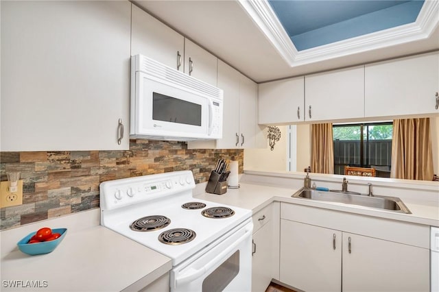 kitchen with backsplash, sink, white appliances, and white cabinets