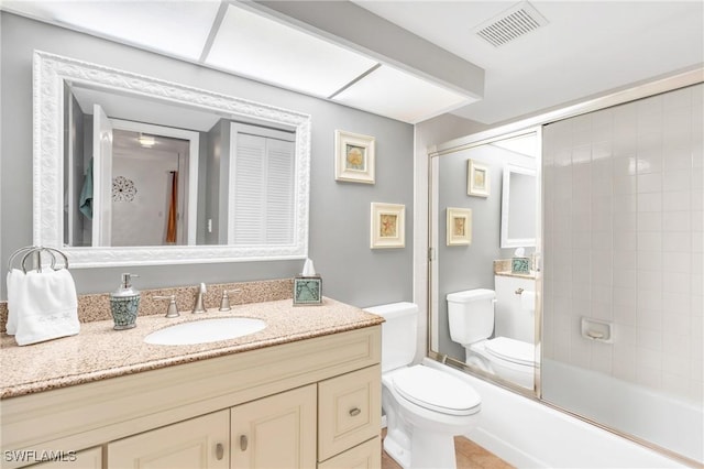 full bathroom with enclosed tub / shower combo, vanity, toilet, and tile patterned flooring