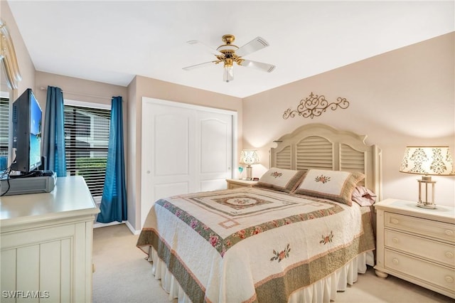 carpeted bedroom featuring ceiling fan and a closet