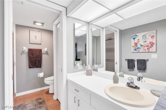 bathroom with toilet, tile patterned flooring, and vanity