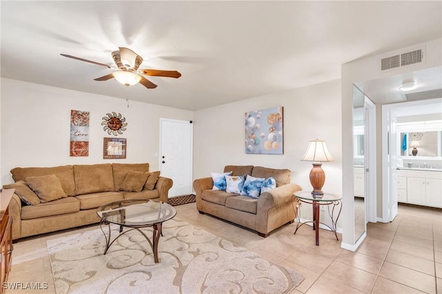 living room featuring ceiling fan, light tile patterned floors, and sink