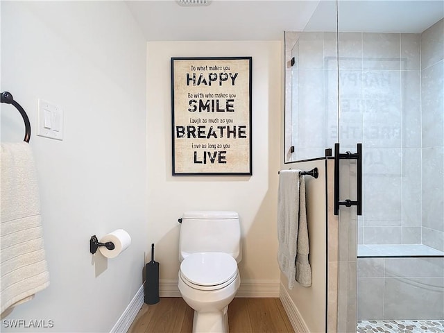 bathroom with an enclosed shower, wood-type flooring, and toilet