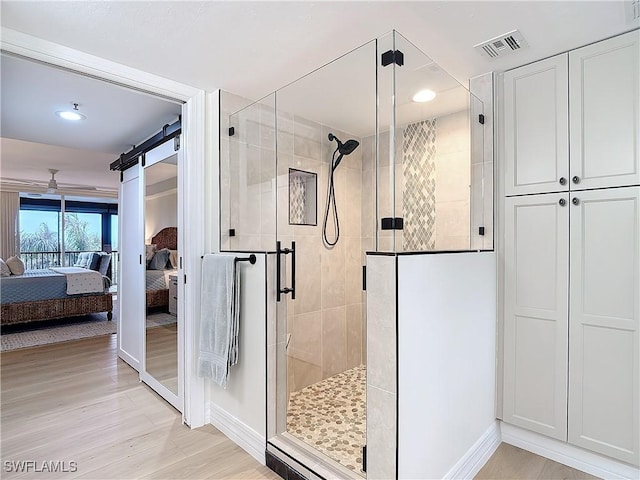 bathroom with an enclosed shower and hardwood / wood-style flooring