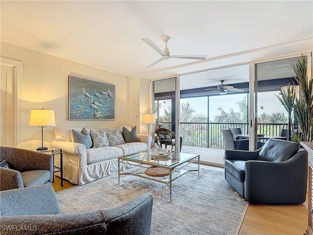 living room featuring light hardwood / wood-style flooring, floor to ceiling windows, and ceiling fan