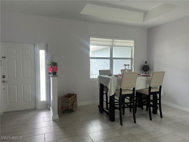 dining space featuring a raised ceiling