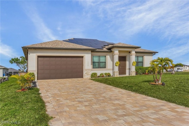 prairie-style house featuring a front lawn, solar panels, and a garage