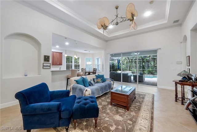 living room featuring light tile patterned floors, ceiling fan, a high ceiling, a tray ceiling, and crown molding