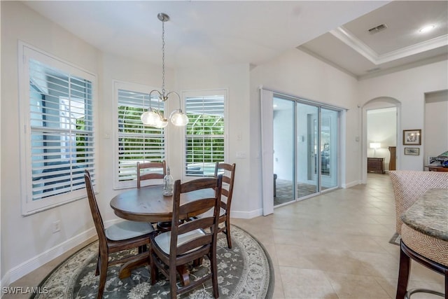 dining room with a tray ceiling, crown molding, and a chandelier