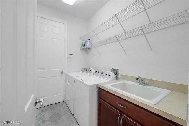 washroom with washer and dryer, sink, and cabinets