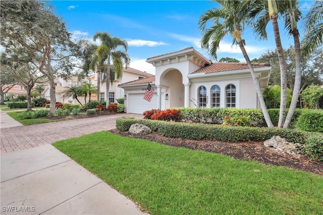 mediterranean / spanish house with a front yard and a garage