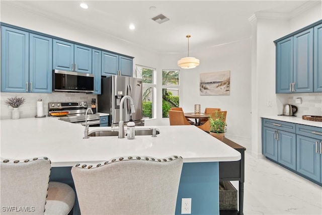 kitchen featuring a breakfast bar area, blue cabinetry, stainless steel appliances, and pendant lighting