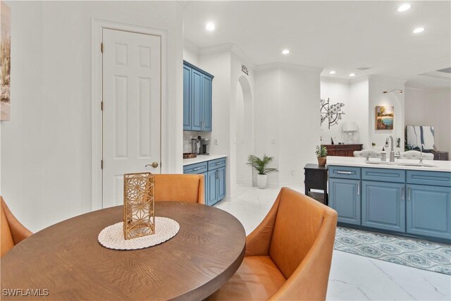 dining space with sink and crown molding