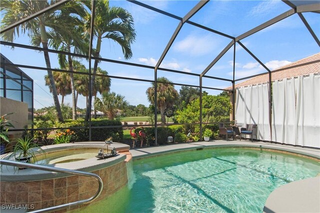 view of pool featuring glass enclosure and a patio area