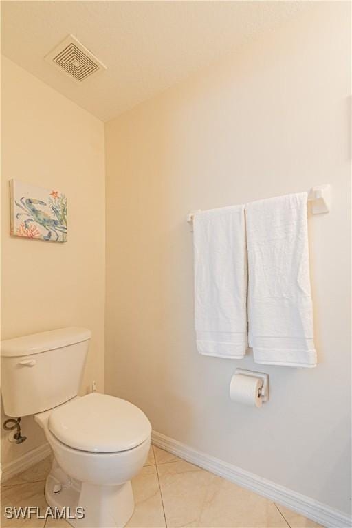 bathroom with toilet and tile patterned floors