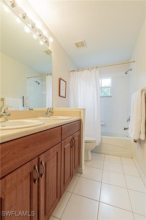 full bathroom with toilet, vanity, tile patterned flooring, and shower / bath combo