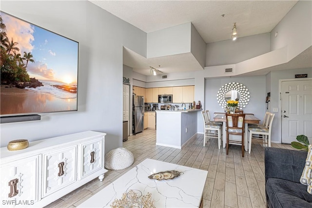 interior space with rail lighting, wood tiled floor, visible vents, and baseboards