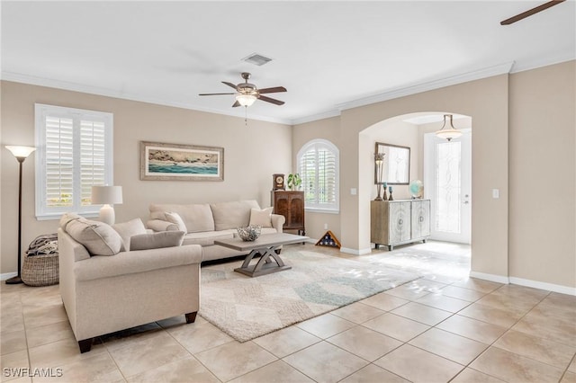 living room with light tile patterned floors, ceiling fan, and ornamental molding