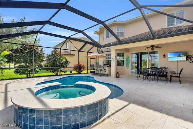 view of swimming pool featuring a lanai, ceiling fan, a patio area, exterior bar, and an in ground hot tub