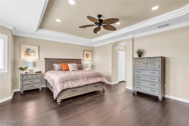 bedroom featuring ceiling fan, a raised ceiling, a closet, dark hardwood / wood-style flooring, and ornamental molding