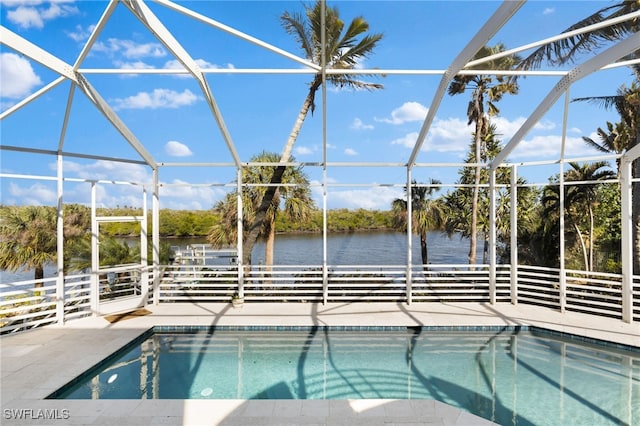 view of swimming pool with a water view, a patio area, and a lanai