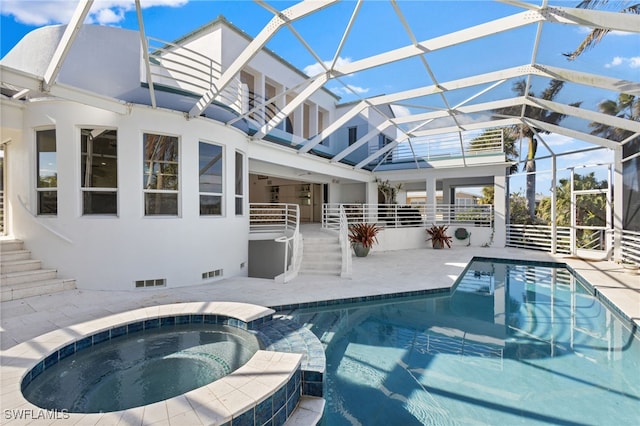 view of pool featuring an in ground hot tub, a patio area, and glass enclosure