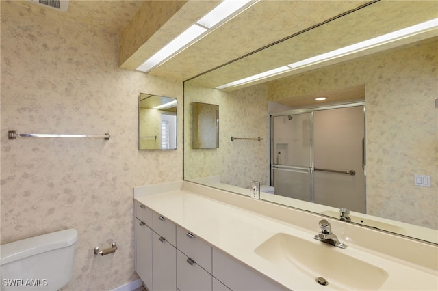 bathroom featuring toilet, walk in shower, and vanity