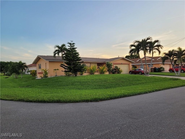 ranch-style home with a yard and a garage