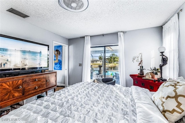 bedroom with access to exterior and a textured ceiling