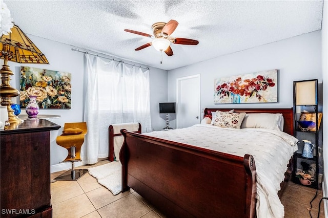 tiled bedroom with ceiling fan and a textured ceiling