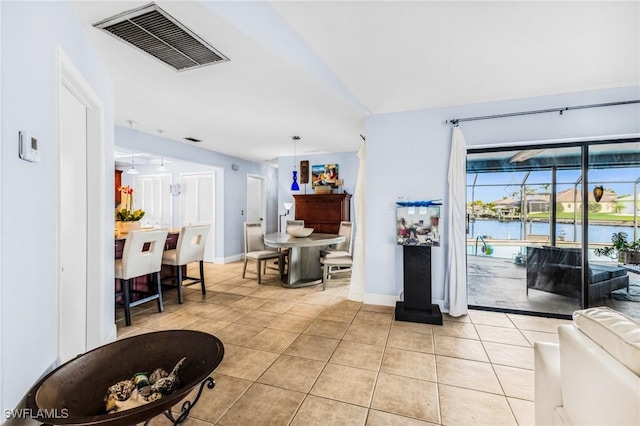 living room with light tile patterned floors and a water view