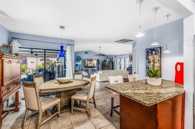 dining area featuring vaulted ceiling, light tile patterned floors, and ceiling fan