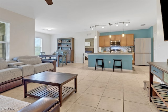 living room with ceiling fan and light tile patterned floors