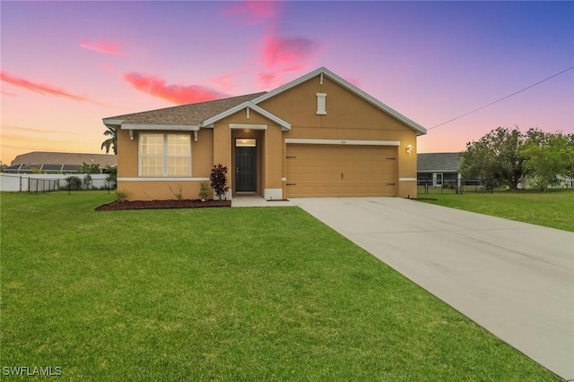 view of front of property featuring concrete driveway, fence, a front lawn, and stucco siding