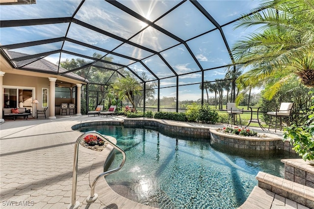 view of pool with glass enclosure, a bar, a patio, ceiling fan, and an outdoor hangout area