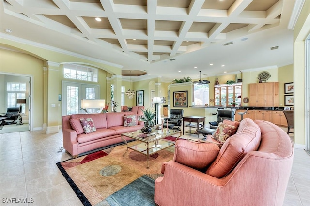 living room with decorative columns, plenty of natural light, crown molding, and light tile patterned flooring