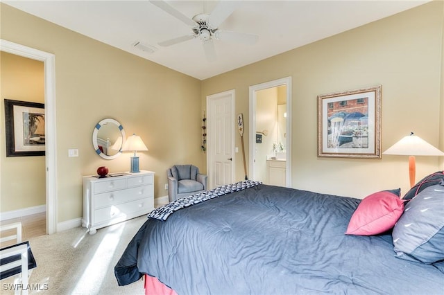 carpeted bedroom with ceiling fan and ensuite bath