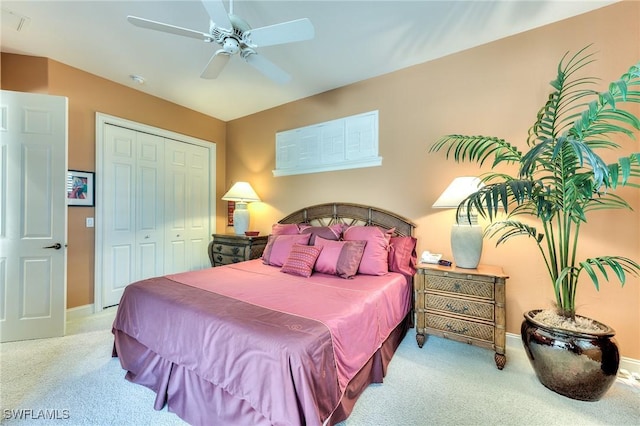 bedroom with ceiling fan, a closet, and light colored carpet