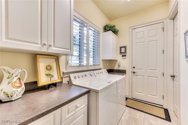 clothes washing area featuring cabinets, separate washer and dryer, and light tile patterned flooring