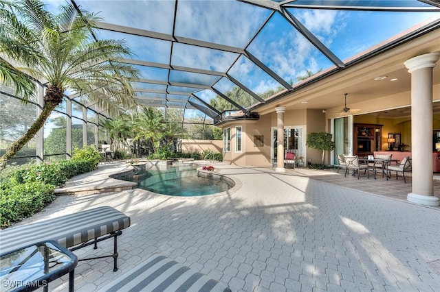 view of swimming pool featuring ceiling fan, a patio area, and glass enclosure