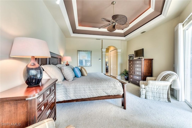 bedroom with carpet floors, crown molding, a raised ceiling, and ceiling fan