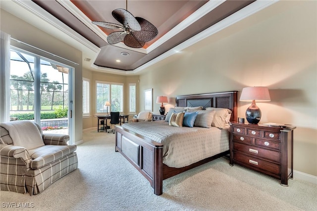 carpeted bedroom with ceiling fan, a tray ceiling, and ornamental molding