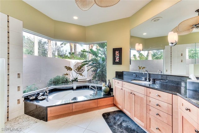 bathroom with tiled bath, tile patterned floors, and vanity