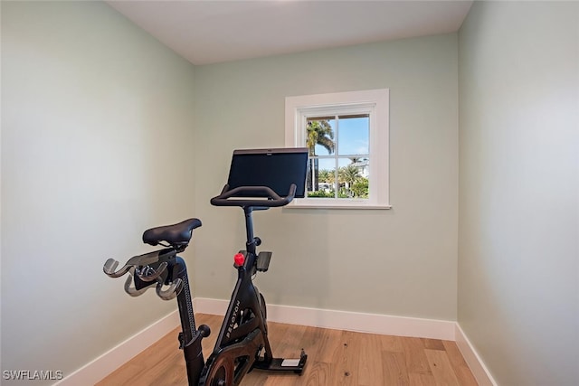 workout room featuring wood finished floors and baseboards
