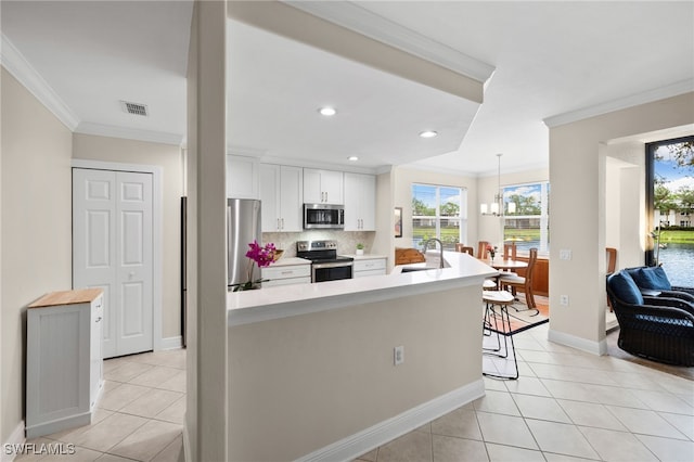 kitchen with appliances with stainless steel finishes, tasteful backsplash, white cabinets, a breakfast bar, and sink