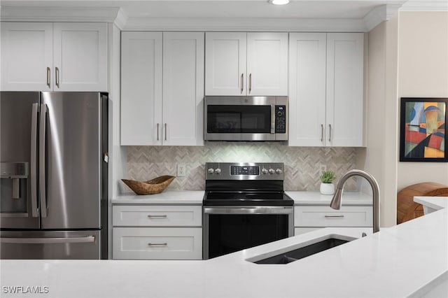 kitchen featuring white cabinets, backsplash, appliances with stainless steel finishes, and sink