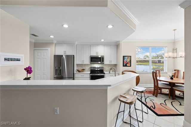 kitchen featuring stainless steel appliances, crown molding, white cabinetry, and a notable chandelier