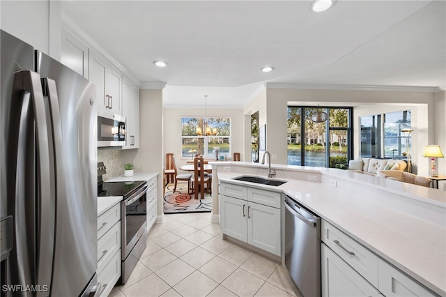 kitchen with white cabinetry, stainless steel appliances, decorative backsplash, sink, and crown molding