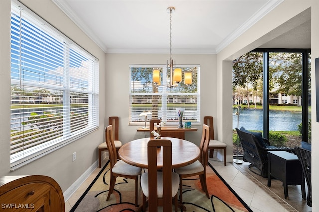 dining area featuring an inviting chandelier, light tile patterned flooring, crown molding, and a water view