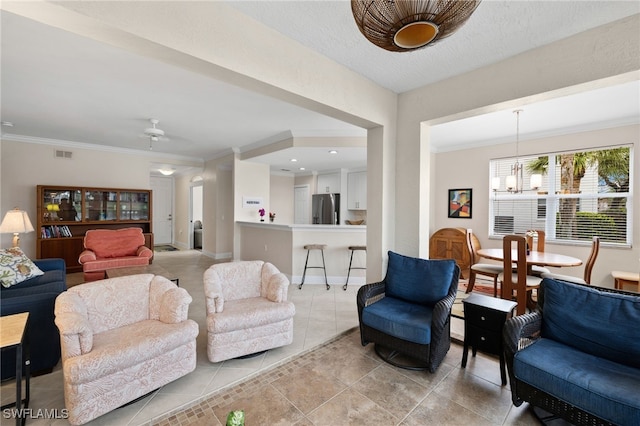 living room featuring ceiling fan with notable chandelier, light tile patterned floors, and ornamental molding