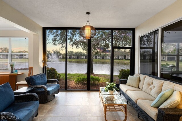 sunroom featuring a water view